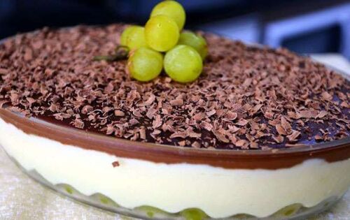 500 g de uva verde sem sementes 3 caixas de creme de leite 2 latas de leite condensado 2 barras de chocolate ao leite 1 barra de chocolate meio amargo 2 colheres de sopa de manteiga. Pique as uvas em peda&ccedil;os pequenos. Derreta os chocolates em banho-maria ou no micro-ondas. Misture com duas caixas de creme de leite e reserve. Derreta a margarina e em seguida acrescente o leite condensado. Mexa at&eacute; ficar parecido com um beijinho, misture com uma caixinha de creme de leite. Em uma tigela de vidro, coloque o creme branco e cubra com os peda&ccedil;os de uva. Deixe no freezer por 15 minutos. Cubra as uvas com o ganache. Leve para gelar.