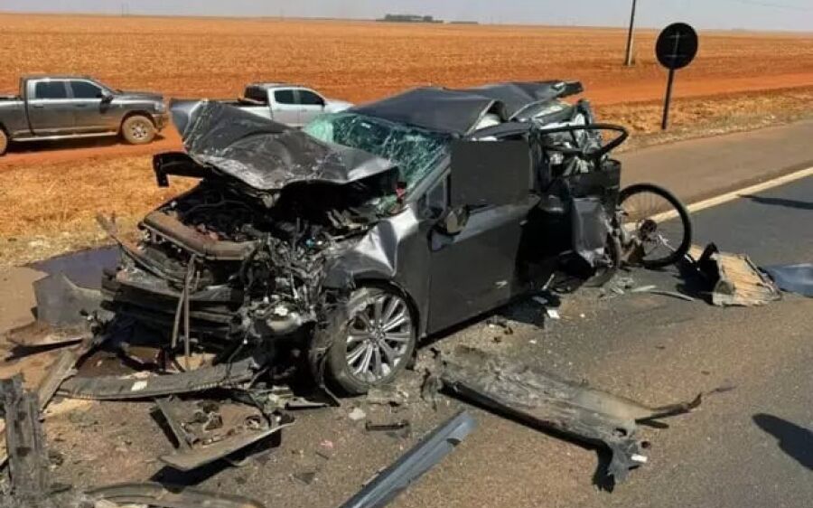 Carro fica destruído após ser prensado por carreta durante pare e siga